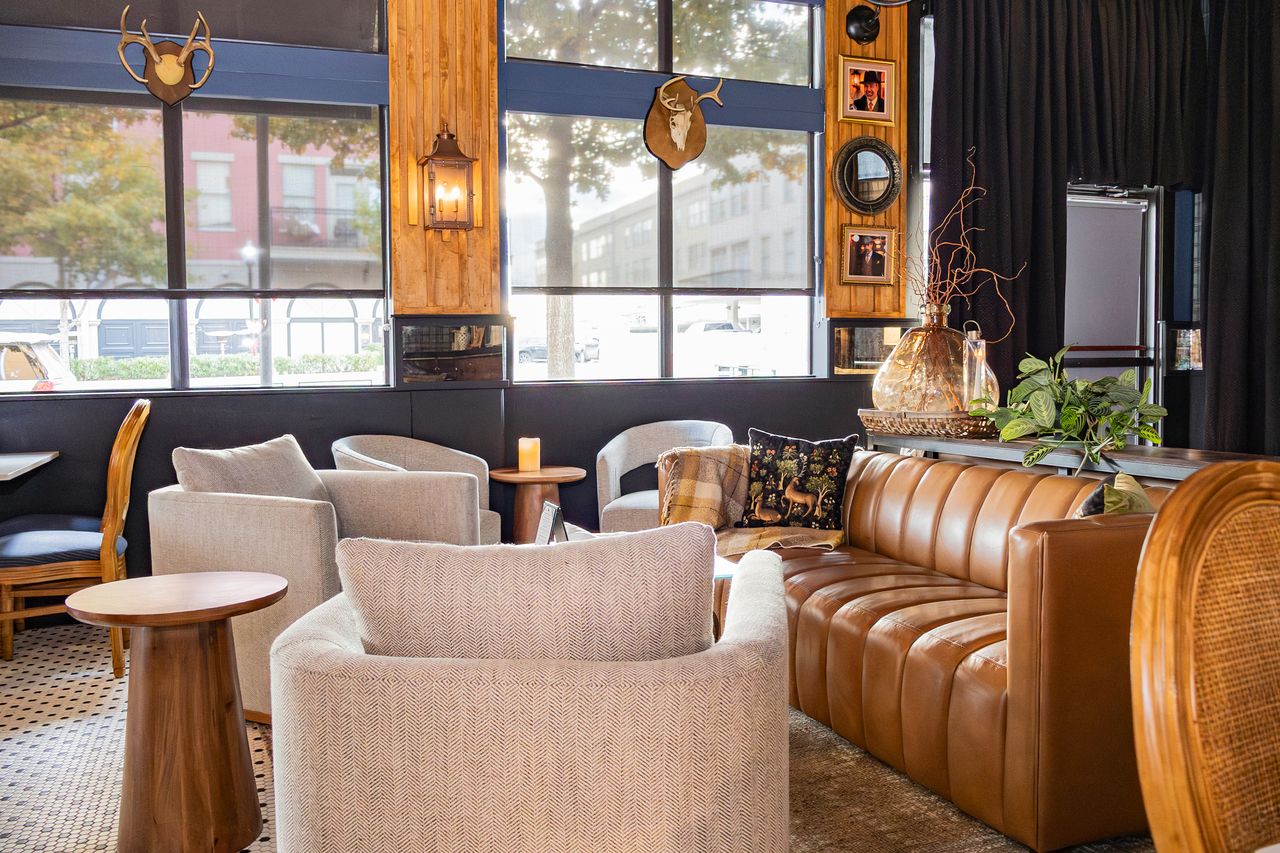 Lounge armchairs and leather sofa by the window at The Boardroom