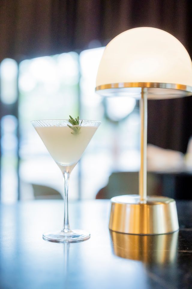Martini beside a brass dome lamp at The Boardroom bar