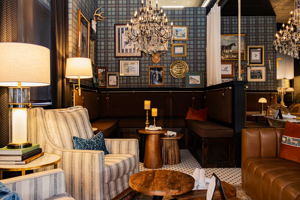 Striped armchairs and crystal chandelier in the lounge at The Boardroom