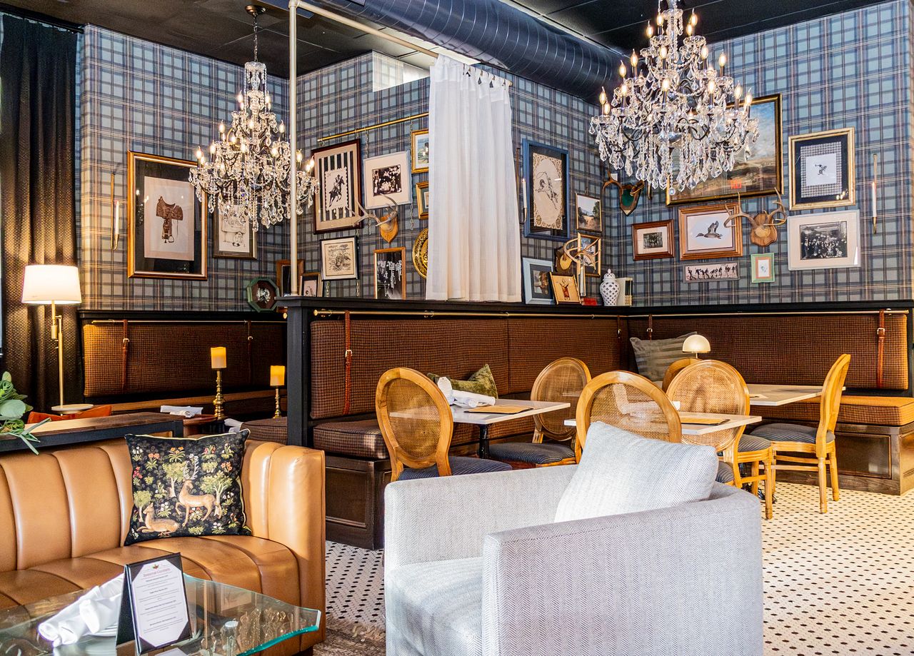 Plaid walls, chandeliers and gallery frames in the dining room at The Boardroom