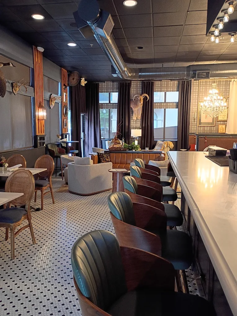 Green leather bar stools along the marble bar at The Boardroom
