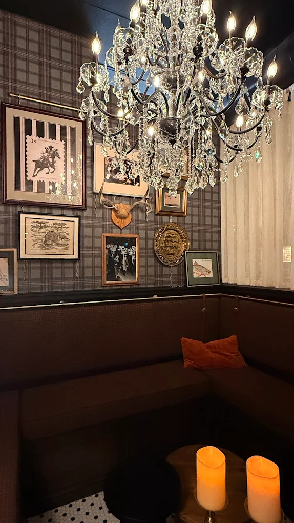 Crystal chandelier and framed gallery wall detail at The Boardroom