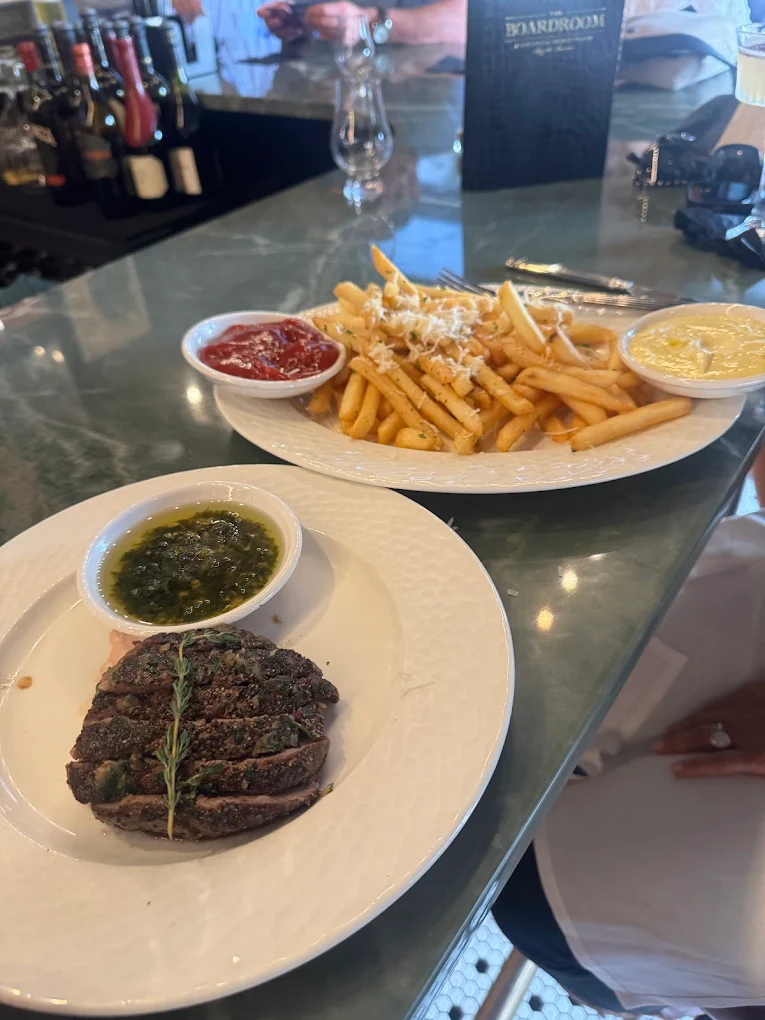 Sliced steak with chimichurri and truffle fries at The Boardroom